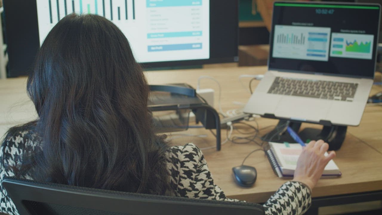 A software facilitator reviewing milestone evidence on multiple screens